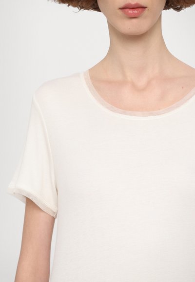 Short-sleeved, round-neck top in off-white textured fabric. Features a smooth neckline and relaxed fit, suitable for various casual settings.