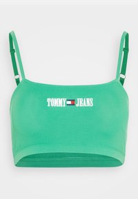 Grön bomullsbustier med justerbara band, med "TOMMY JEANS" broderat i vitt ovanför en detalj med röd, vit och blå logotyp.