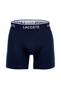 Boxer aderenti blu navy con elastico nero che presenta il logo bianco "LACOSTE". Realizzati in un tessuto morbido ed elastico con un design aderente.