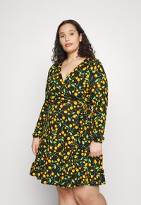 Vestido preto envolvente com mangas longas, apresentando um padrão de cerejas verdes e amarelas, bainha de volantes e decote em V. Feito de um tecido macio.