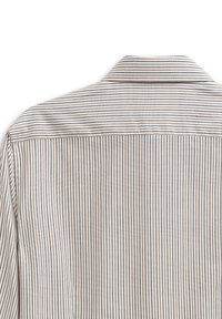 Camicia bianca a strisce con sottili strisce verticali nere e marroni, dotata di colletto classico e texture di tessuto liscia.