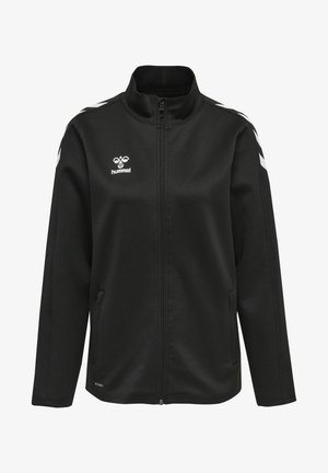Schwarze Zip-Jacke aus weichem Stoff, mit weißen diagonalen Streifen auf den Schultern und einem Logo auf der linken Brust. Flacher Kragen, seitliche Taschen.