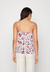Floral camisole with thin straps, featuring a white background and multicolored flower patterns in pink, purple, and orange hues.
