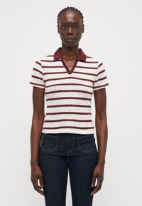 Stripet strikket topp med korte ermer, i maroon og kremfarger, med V-hals og en kontrasterende maroon krage.