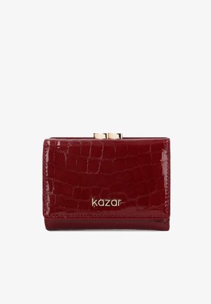 Mały błyszczący ciemnoczerwony portfel o fakturze krokodyla, złote zapięcie na górze i logo "kazar" w złotych literach na przodzie.