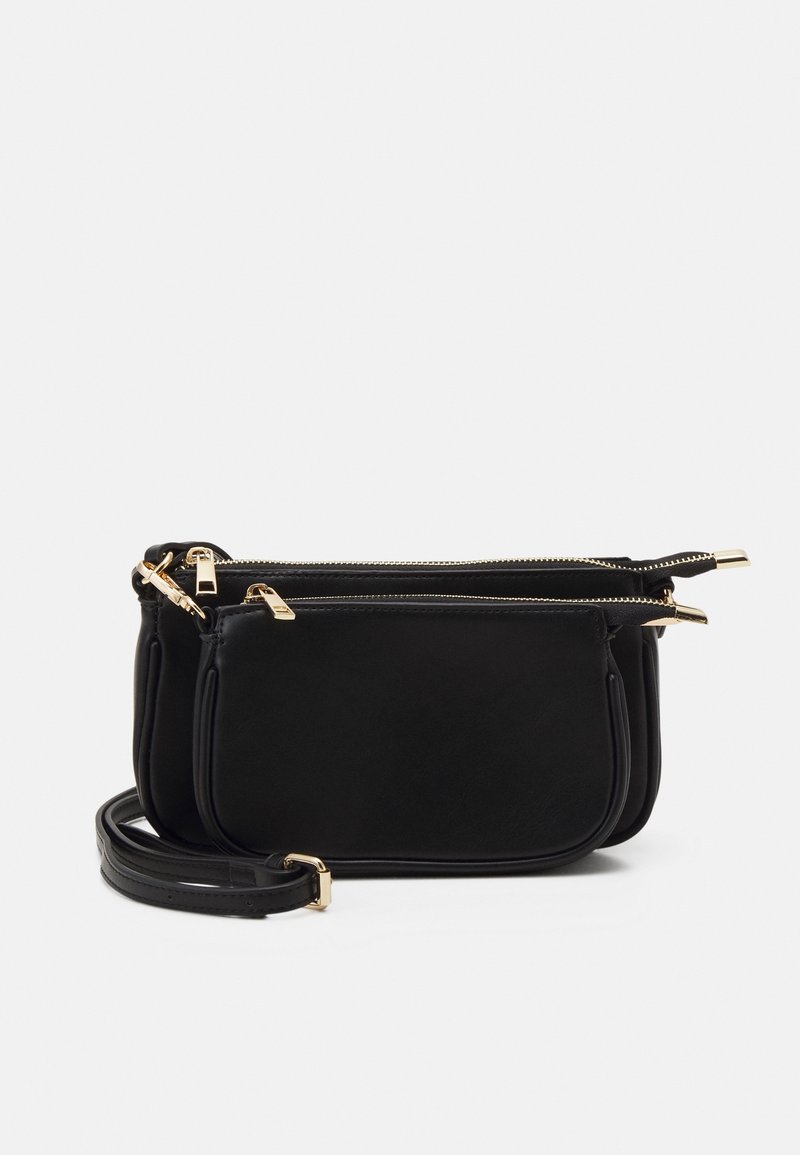 Czarna skórzana torba na ramię z zamykanymi na zamek przegródkami, złotymi elementami i wąskim regulowanym paskiem. Gładka faktura, minimalistyczny design.