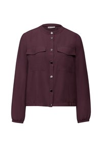 Blouse bordeaux boutonnée en tissu léger, avec col rond, deux poches poitrine et poignets élastiques. Texture lisse.