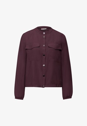 Vínová košile na knoflíky vyrobená z lehké látky, s kulatým límcem, dvěma náprsními kapsami a elastickými manžetami. Hladká textura.