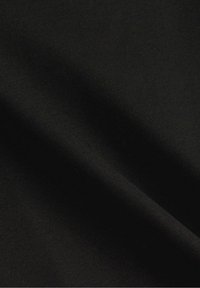 Tissu noir lisse avec des plis diagonaux doux et une texture fine.