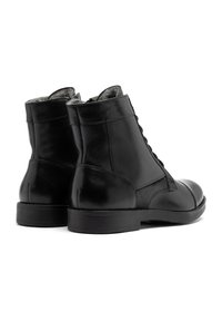 Czarne skórzane botki za kostkę z gładkim wykończeniem, sznurowanym designem i okrągłym czubkiem. Akcenty w postaci teksturalnych paneli oraz gumowe podeszwy.