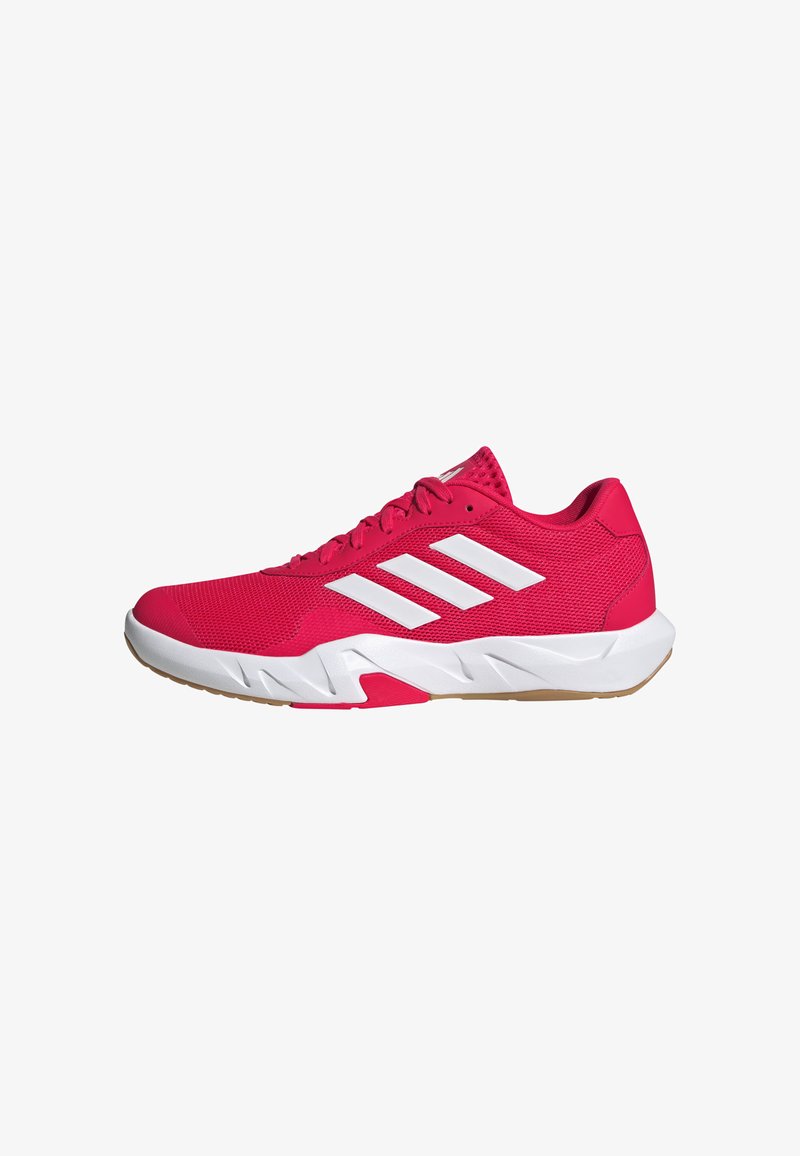 Zapatillas deportivas rosas con una parte superior de malla texturizada, logo de tres franjas en blanco y una suela blanca contrastante con un patrón de tracción de goma.
