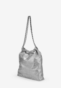 Bolso de hombro plateado metálico con parte superior fruncida y cadena, que presenta una textura suave y una forma blanda y relajada.