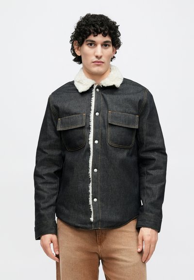 Džínová bunda s límcem z beránka, dvěma náprsními kapsami a kontrastním prošíváním. Tmavě modrošedá barva s jemnou texturou.
