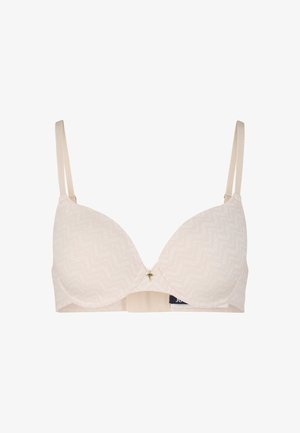 Nude bra with smooth, padded cups featuring subtle zigzag pattern, adjustable straps, and a small gold accent at the center front.