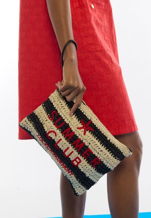 Bolso de mano de paja trenzada con rayas negras y beige, que presenta el texto rojo "SUMMER CLUB" y un adorno de estrella de mar. Cuenta con una correa de muñeca negra.