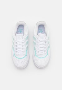 Białe trampki z jasnoniebieskimi akcentami, trzema paskami, perforowanymi czubkami i teksturowaną gumową podeszwą. Na języku widoczne jest logo marki.