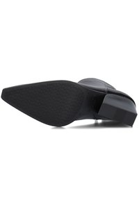 Botín negro con suela de goma texturizada y tacón cuadrado, que presenta un upper de cuero liso y detalles de costura mínimos.