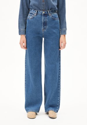 Hochgeschnittene weit geschnittene Jeans in mitteldunkelblauem Denim. Zu den Merkmalen gehören fünf Taschen, Metallbeschläge und ausgefranste Säume.