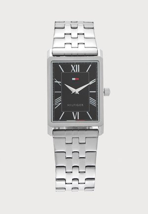 Silberne Metallglieder-Armbanduhr mit rechteckigem schwarzem Zifferblatt, weißen römischen Ziffern, zwei silbernen Zeigern und Hilfiger-Logo unterhalb von 12 Uhr.