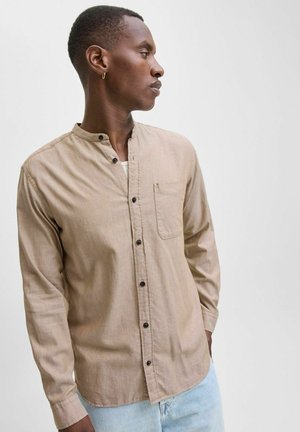 Light brown long-sleeve shirt with a mandarin collar, front pocket, and dark buttons. Smooth fabric with a subtle texture.