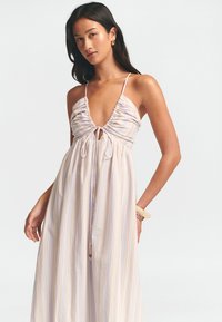 Robe maxi légère à rayures dans des couleurs pastel. Elle présente un décolleté en V profond, un corsage froncé, des bretelles ajustables et un détail à nouer au centre.