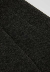 Svart texturerat tyg med en mjuk, ludig yta och en lätt glans. Materialet verkar tätt och varmt, lämpligt för ytterkläder eller accessoarer.