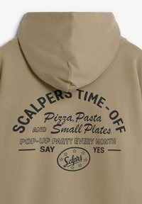 Khakifarbenes Kapuzensweatshirt mit schwarzem grafischem Text. Das Design enthält Phrasen und ein kreisförmiges Logo am unteren Ende. Glatte Textur, lässiger Stil.