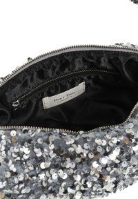Clutch din argint acoperit cu paiete, cu căptușeală interioară din satin negru și buzunar interior cu fermoar etichetat "Part Two."