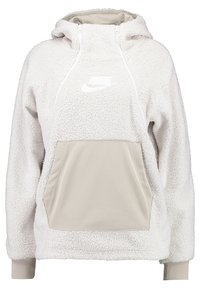 Fleecová mikina s kapucí v světle béžové barvě s texturovaným, načechraným povrchem, kontrastní béžovou kapsou a bílým logem na hrudi.