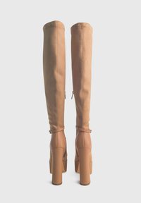 Stivali over-the-knee in suede tan con tacco a blocco chunky, dotati di zip laterale e cinturini alla caviglia per un tocco di stile. Texture liscia su tutta la superficie.