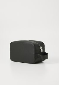 Black rectangular cosmetic bag made of smooth material. Features a silver zipper and a side handle for easy carrying.