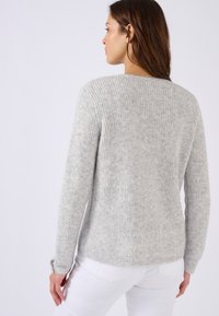Grauer Strickpullover mit strukturierter Oberfläche und Fischgrätmuster am Saum. Gerippter Halsausschnitt und Bündchen, mit langen Ärmeln.