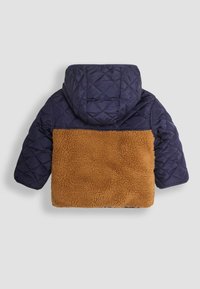 Giacca trapuntata blu navy con retro in pelliccia marrone, cappuccio e maniche lunghe. Presenta una parte superiore in pelliccia testurizzata e una sezione inferiore liscia.