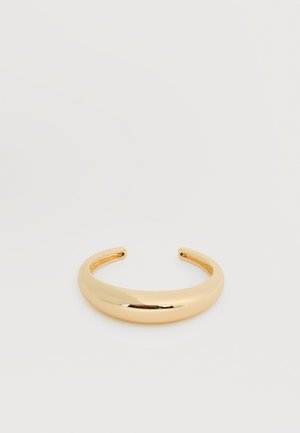 Bracelet manchette en or lisse et brillant avec un design légèrement incurvé et ouvert sur un fond blanc uni.