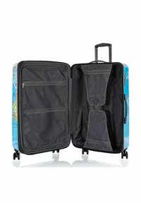 Valigia rigida con design in blu a mappa, interno nero, numerosi scomparti con zip, e maniglia estensibile con ruote.