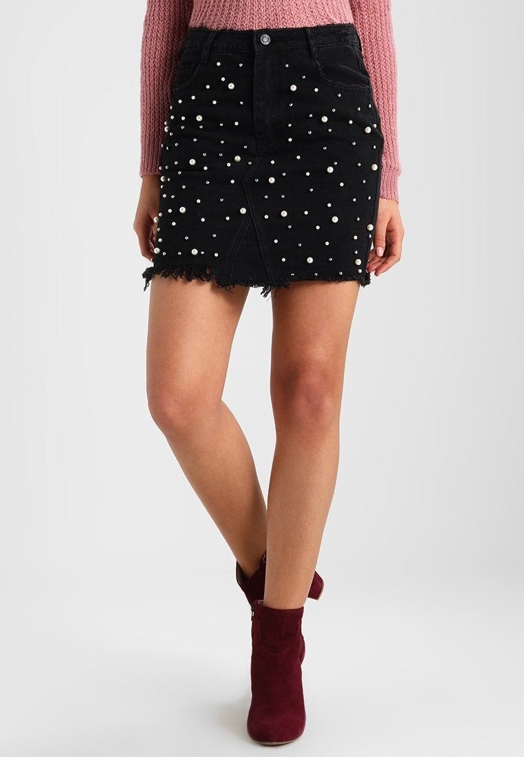 Svart denim mini kjol med pärlprydnader, franskant och veck fram. Kombinerad med bordeauxfärgade ankelboots.