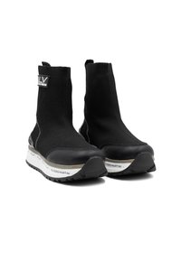 Zwarte enkellange sneakers met een gebreide bovenkant, rubberen neuskap en witte buitenzool met merkaccenten. Gelaagd en gestroomlijnd ontwerp.