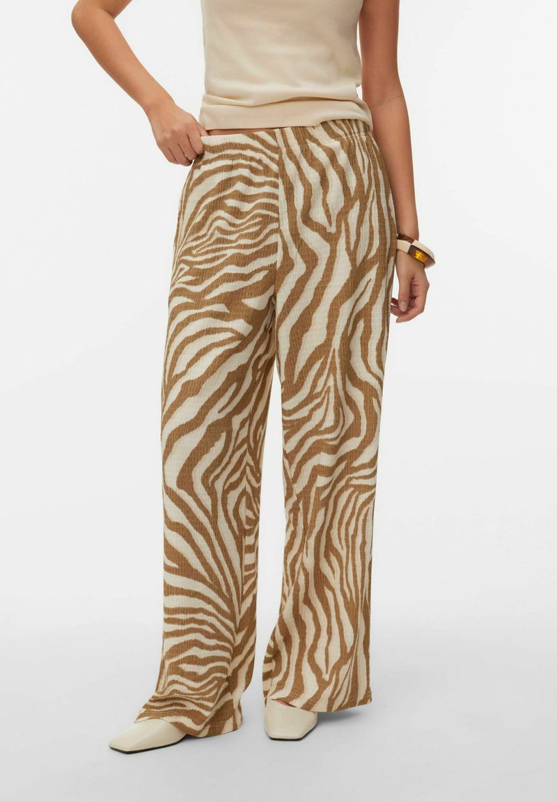 Pantalon à jambes larges avec un motif à rayures zébrées beige et marron. Confectionné en tissu texturé avec une ceinture élastique.