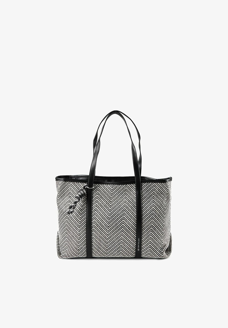 Sac fourre-tout à motif chevrons noir et blanc avec de longues anses noires et un petit accessoire tressé sur un côté.