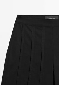 Zwarte op maat gemaakte broeken met een gladde textuur, voorzien van subtiele plooien, een platte tailleband en een label van Massimo Dutti.