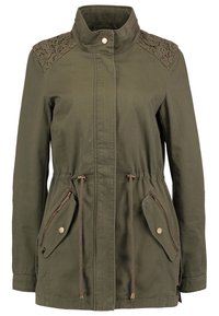 Olivgrön jacka med hög krage, dragsko i midjan och intrikata spetsdetaljer på axlarna. Har två fickor med dragkedja fram.