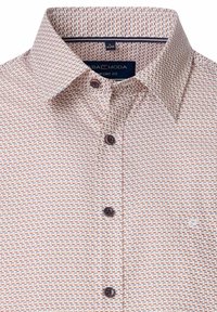 Jasno kolorowa koszula z guzikami, zdobiona geometrycznym wzorem w odcieniach czerwieni, niebieskiego i pomarańczowego, z rozłożonym kołnierzykiem i ciemnymi guzikami.