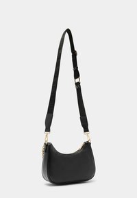 Borsa a tracolla in pelle nera con forma curvata, hardware dorato e un manico rimovibile in tessuto testurizzato. Chiusura superiore con zip.