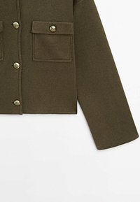 Olive green cropped jacket with two front pockets, gold buttons, and a soft, textured fabric. Straight sleeves and clean edges.