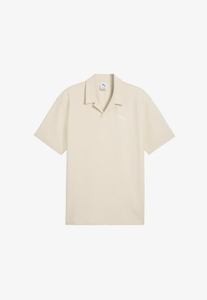 Polo beige a maniche corte con una texture morbida, colletto aperto e logo Puma discreto sul petto sinistro.