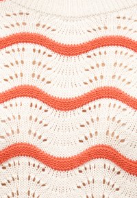 Tissu blanc en maille avec un motif ondulé créé par des rayures en fil orange en relief et des détails ajourés en dentelle.