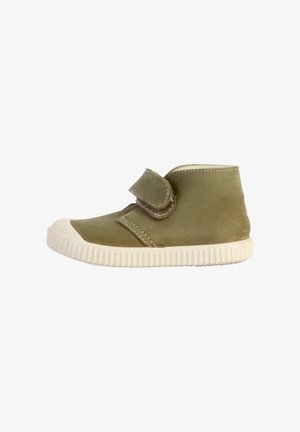 Botte cheville en daim vert avec un capuchon en caoutchouc blanc, une bande Velcro et une semelle texturée. Caractéristiques de lignes d'accent cousues.