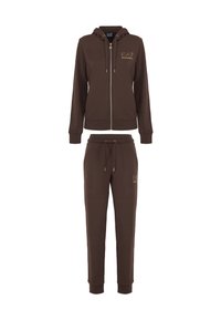 Completo felpa marrone con zip e pantaloni abbinati, realizzato in tessuto morbido; presenta tasche laterali e accenti con logo dorato sulla parte frontale.