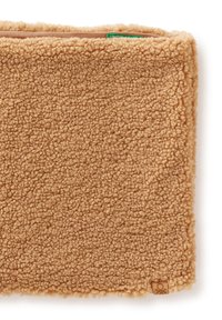 Bufanda de tela marrón clara, esponjosa, con superficie texturizada y una pequeña etiqueta marrón con un logo. Los bordes están cuidadosamente rematados.