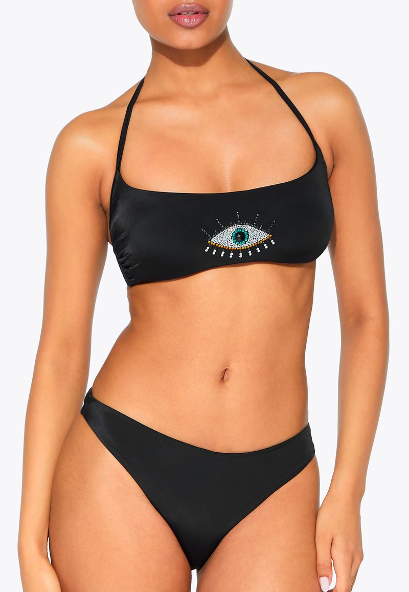 Zwarte bikini set met een bandeau top waarop een kleurrijk oogdesign van rhinestones is afgebeeld. De onderkant is eenvoudig, met een gladde textuur en minimale bedekking.